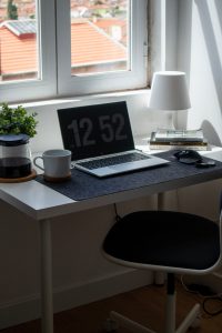 mesa de trabalho com um notebook mostrando a hora