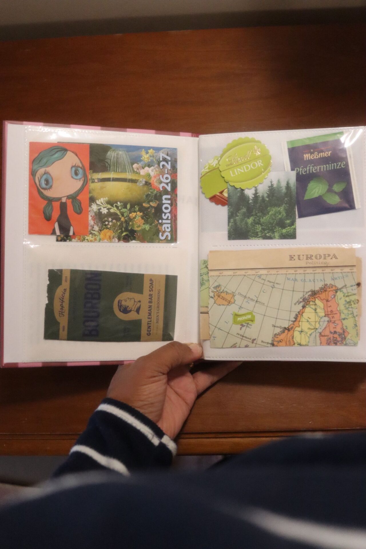 Página verde do álbum de recortes com ilustração de menina, embalagem de chá Meßmer de hortelã, rótulo de chocolate Lindt e um mapa antigo da Europa